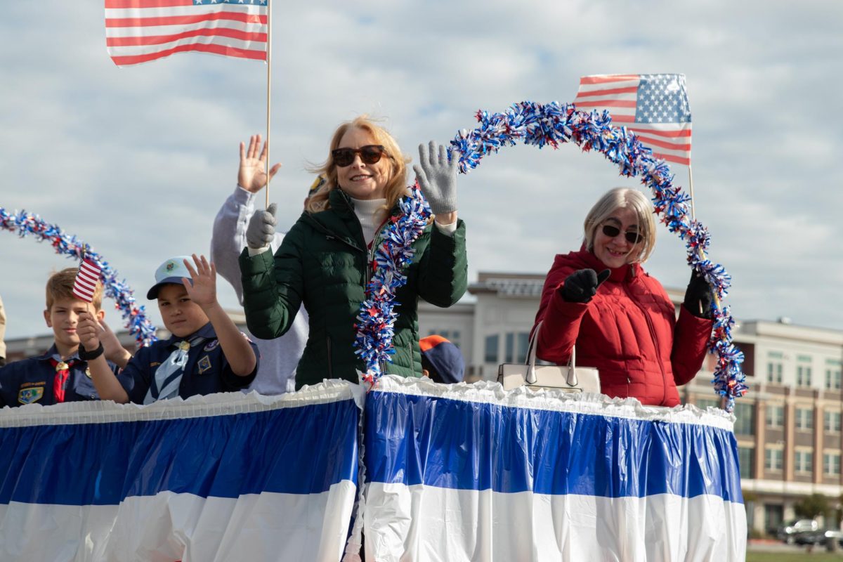 Veteran family waves at the crowd while going through the Frisco Community Parade. 