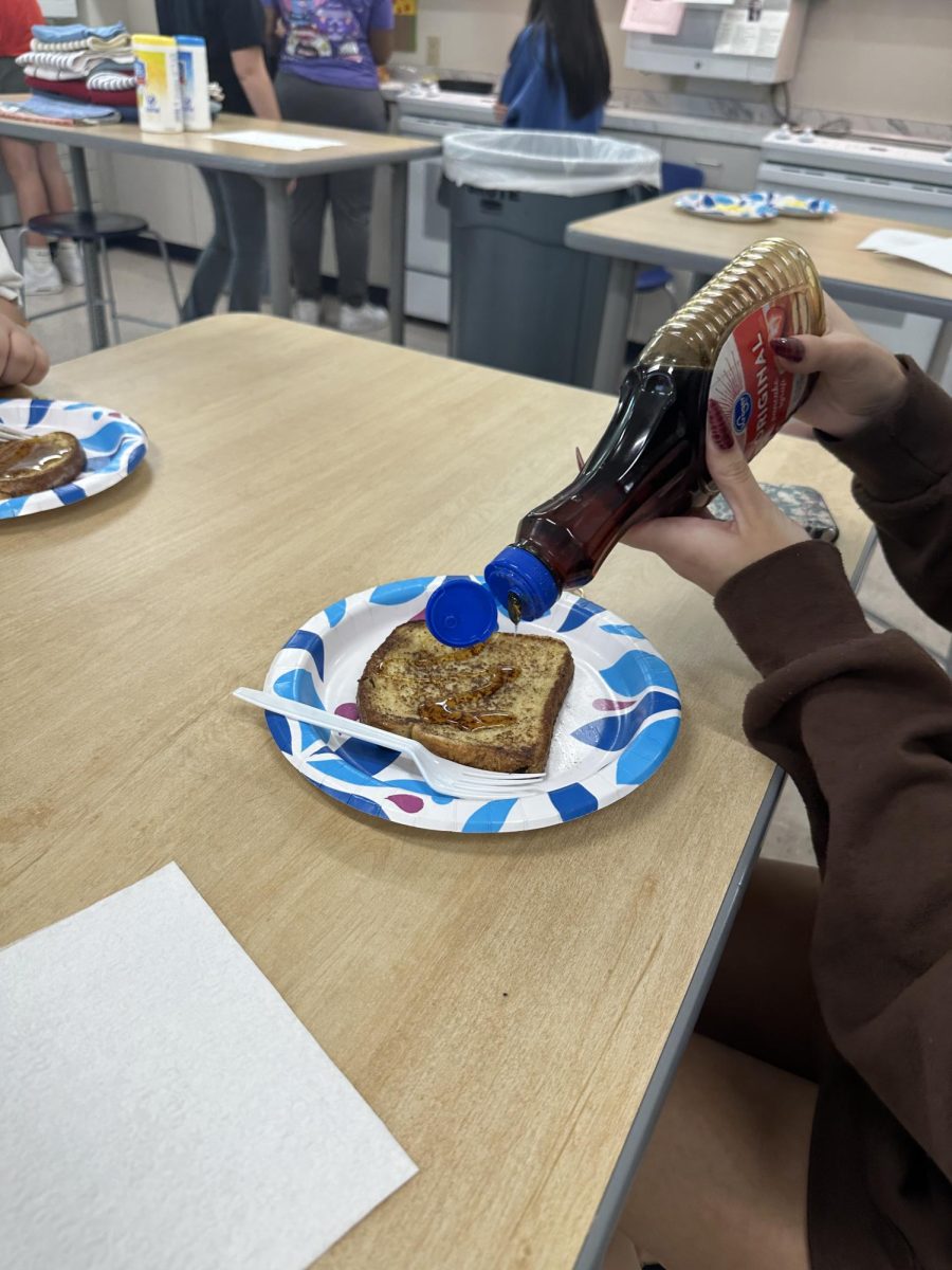 Paige Gordillo, '25, garnishes her food after the French toast lab on Sept. 12.