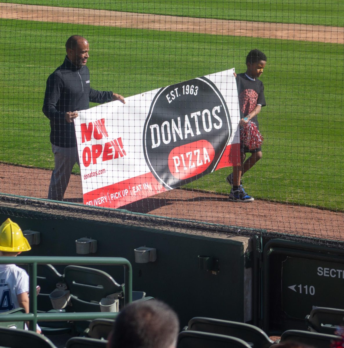 Representatives from Donato's Pizza walk along the field during the Community Pep Rally. 