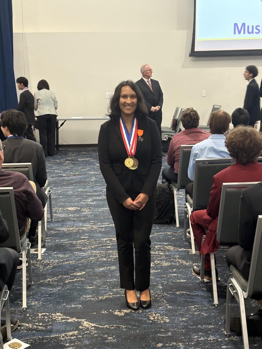 Vijay posing with the medals she won at Texas's Academic Decathlon competition. 